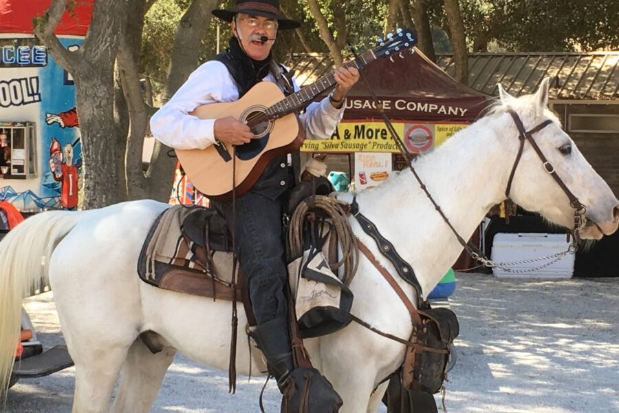 Horseman playing guitar and singing while sitting on a horse